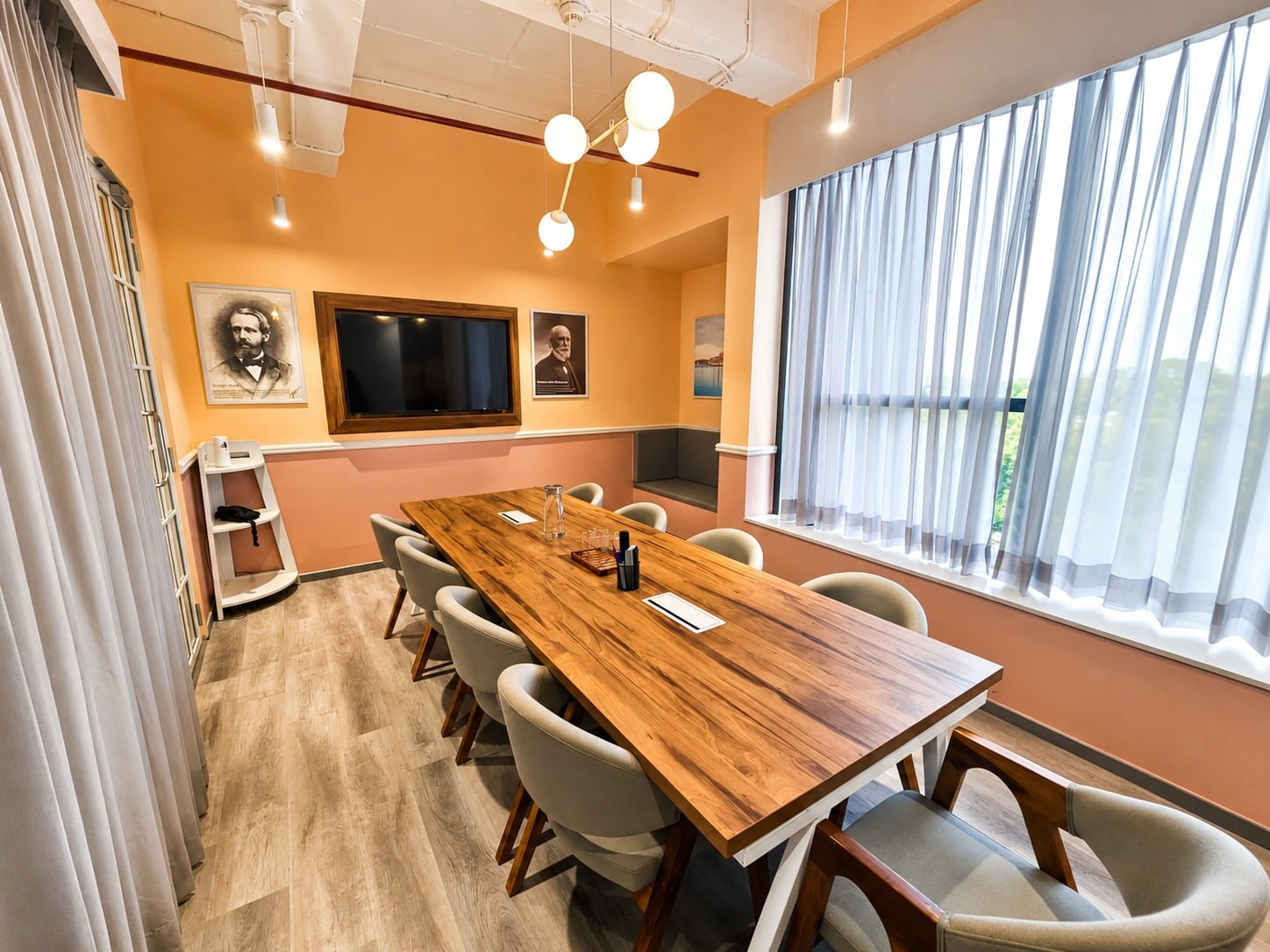 Green-themed discussion room at MAGICX with a whiteboard and mounted display screen